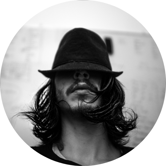 Black-and-white portrait of Cyril Nima wearing a hat